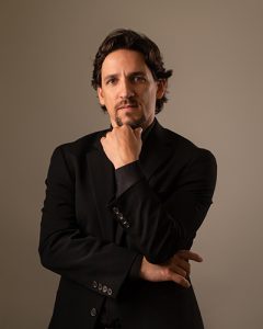Man head on hand looking at camera in a black jacket